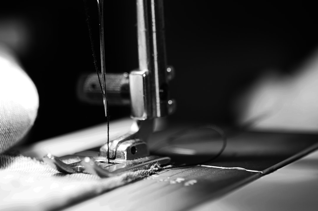 10 Essential Clothing Alterations Explained | Online Alterations & Tailor Guide 1 A black and white close up photo of a sewing machine altering clothes
